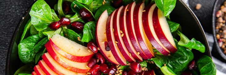 apple salad, green mix lettuce, pomegranate grain healthy meal food snack on the table copy space...