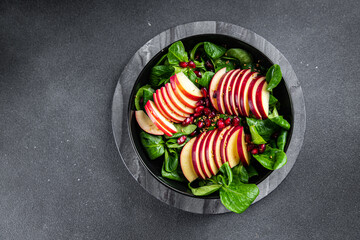 apple salad, green mix lettuce, pomegranate grain healthy meal food snack on the table copy space food background rustic top view keto or paleo diet veggie vegan or vegetarian food