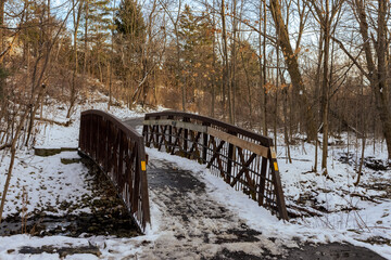 Creek and bridge in Burlington park covered in snow in winter, Ontario, Canada.