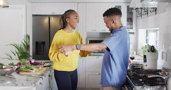 Happy african american couple dancing in kitchen