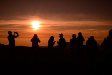 Fototapeta na wymiar A group of young people watching the sun rise from the top of Mount Inthanon