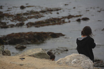 child on the beach, enjoying the ocean and tide pools. Concept of contemplation, relaxation, room for ad copy or text