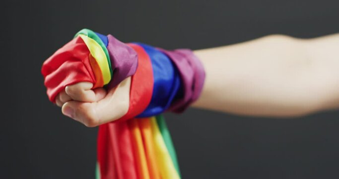 Video of hand of caucasian man with rainbow ribbon