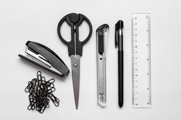writing materials. black pen, stapler, scissors, ruler, paper clips, stationery knife