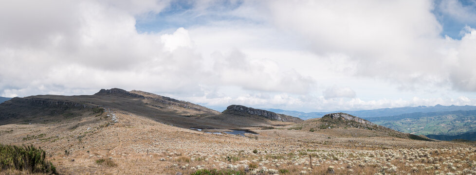 Rocky paramo landscape with fog and lake in a cloudy day