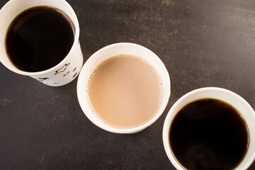 Coffee and coffee with milk in some disposable cups on a table in the office