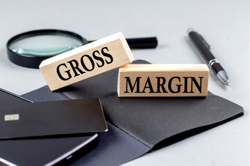 GROSS MARGIN text on wooden block on black notebook , business concept