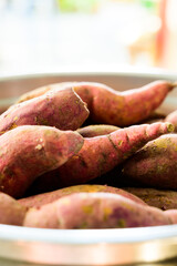 Fresh sweet potatos in stainless steel bowl