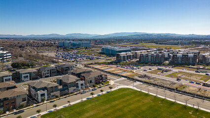 Fototapeta na wymiar Aerial photos over apartments and houses in Dublin, California with a green field and solar panels