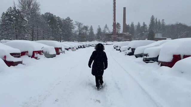 Girl Walking Down A Snowed In Parking Lot