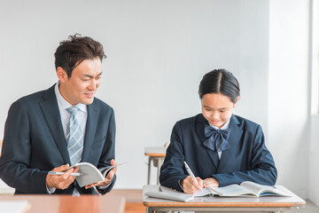 学校・塾で個別指導・マンツーマン指導する中学生・高校生・小学生と先生・教師・塾講師

