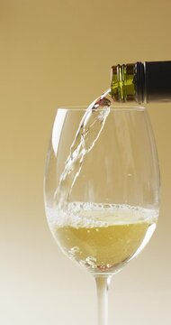 Vertcal video of white wine pouring into glass