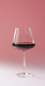 Vertical video of red wine glass on marsala background