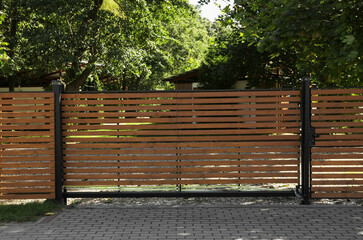 Closed wooden gates near beautiful green trees