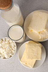 Tasty homemade butter and dairy products on white textured table, flat lay