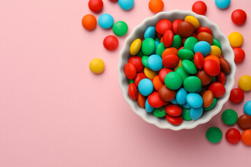 Tasty colorful candies on pink background, flat lay. Space for text