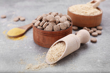 Different types of brewer's yeast on grey table, closeup