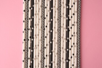 Many paper drinking straws on pink background, flat lay