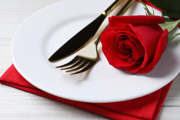 Fototapeta na wymiar Beautiful place setting with dishware and rose for romantic dinner on white wooden table, closeup