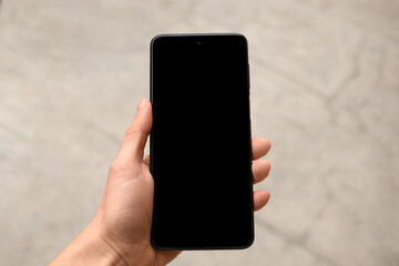 Woman holding smartphone with blank screen outdoors, closeup