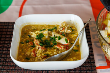 A crab and tofu dish with ginger in a serving bowl