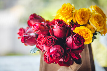 Yellow and red roses in cloth bags from the market.
