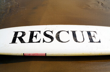 Black Rescue Sign on White Surfboard 