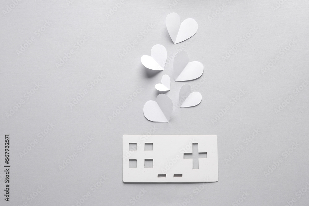 Wall mural paper retro gamepad icon with hearts on gray background. paper art