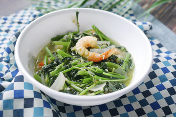 Top view of bowl with cooked spinach on table 