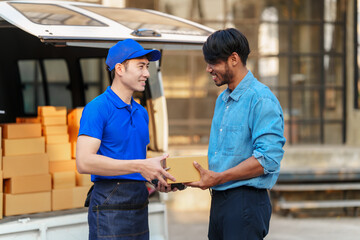 Obraz premium Delivery man asia people checking portable delivery device with parcel box to customer home address. give delivery box to customer and sign a signature of receiver people