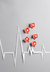 Paper cut heart rate cardiogram with Social media likes on gray background. Creative minimal layout