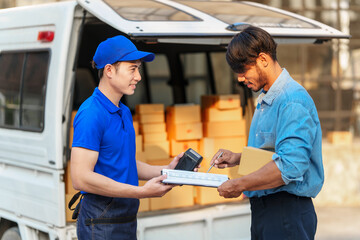 Delivery man asia people checking portable delivery device with parcel box to customer home address. give delivery box to customer and sign a signature of receiver people