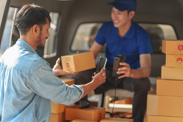Delivery man asia people checking portable delivery device with parcel box to customer home address. Using mobile scan qr code on EDC machine.