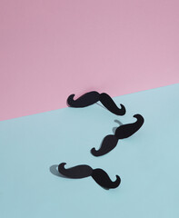 Paper-cut mustache on blue-pink pastel background. Creative minimal layout. Father's day