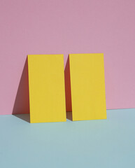 Yellow blank business cards on a blue-pink pastel background. Creative minimal layout. Corporate identity