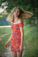 Fototapeta premium Portrait of a young beautiful girl with disheveled hair in a summer forest.