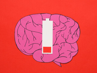 Paper-cut brain with low battery level on red background. Mental health concept