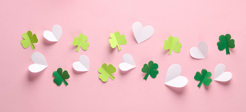 Paper-cut heart and clover leaves on a pink background. St.Patrick 's Day