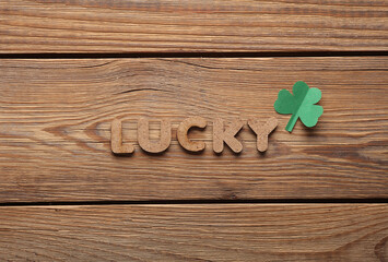 St.Patrick 's Day. Word lucky with clover leaves on wooden background