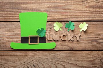 Saint patrick's day celebration. Paper-cut leprechaun hat and word lucky on wooden background. Flat...
