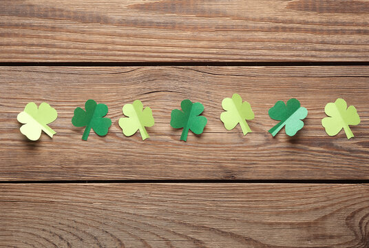 St.Patrick 's Day. Paper clover leaves on wooden background. March 17. Hand made, Paper art. Flat lay. Top view