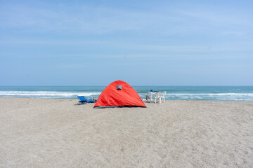 Background photos of a tent on the beach with a blue sky.