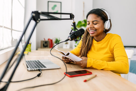 Young Female Creator Recording Radio Podcast On His Room. Millennial Teen Girl Influencer With Headphones Online Live Talking To Audience Using Microphone And Laptop