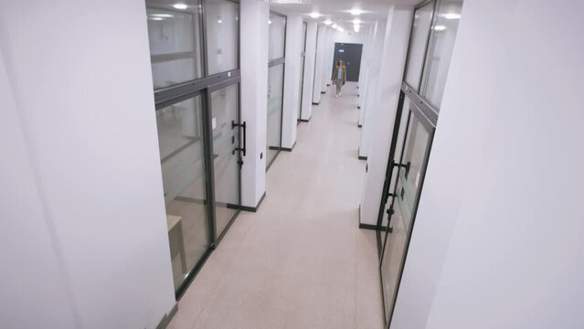 View from security cameras in the business center. Woman and man walk in the corridor, then stop and start talking. Concept of tracking system, monitoring and safety. Security camera shooting.