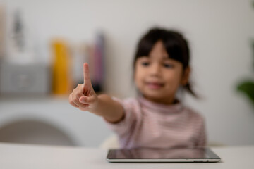 education, school, and imaginary screen concept - Asian little girl pointing in the air or imaginary screen