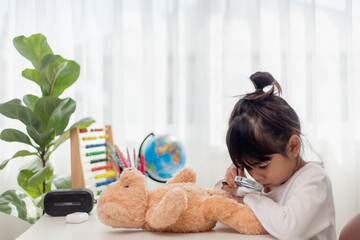 Child playing with teddy bear. Asian little girl hugging his favorite toy. Kid and stuffed animal...