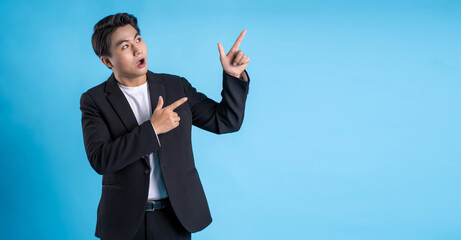 Young business man wearing a vest posing on a blue background