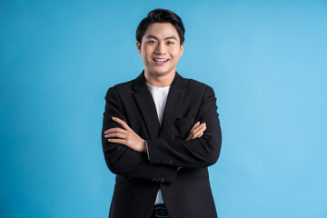 Obraz na płótnie Canvas Young business man wearing a vest posing on a blue background