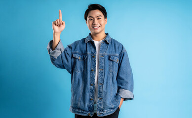 Naklejka premium Young asian man posing on a blue background