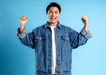 Young asian man posing on a blue background